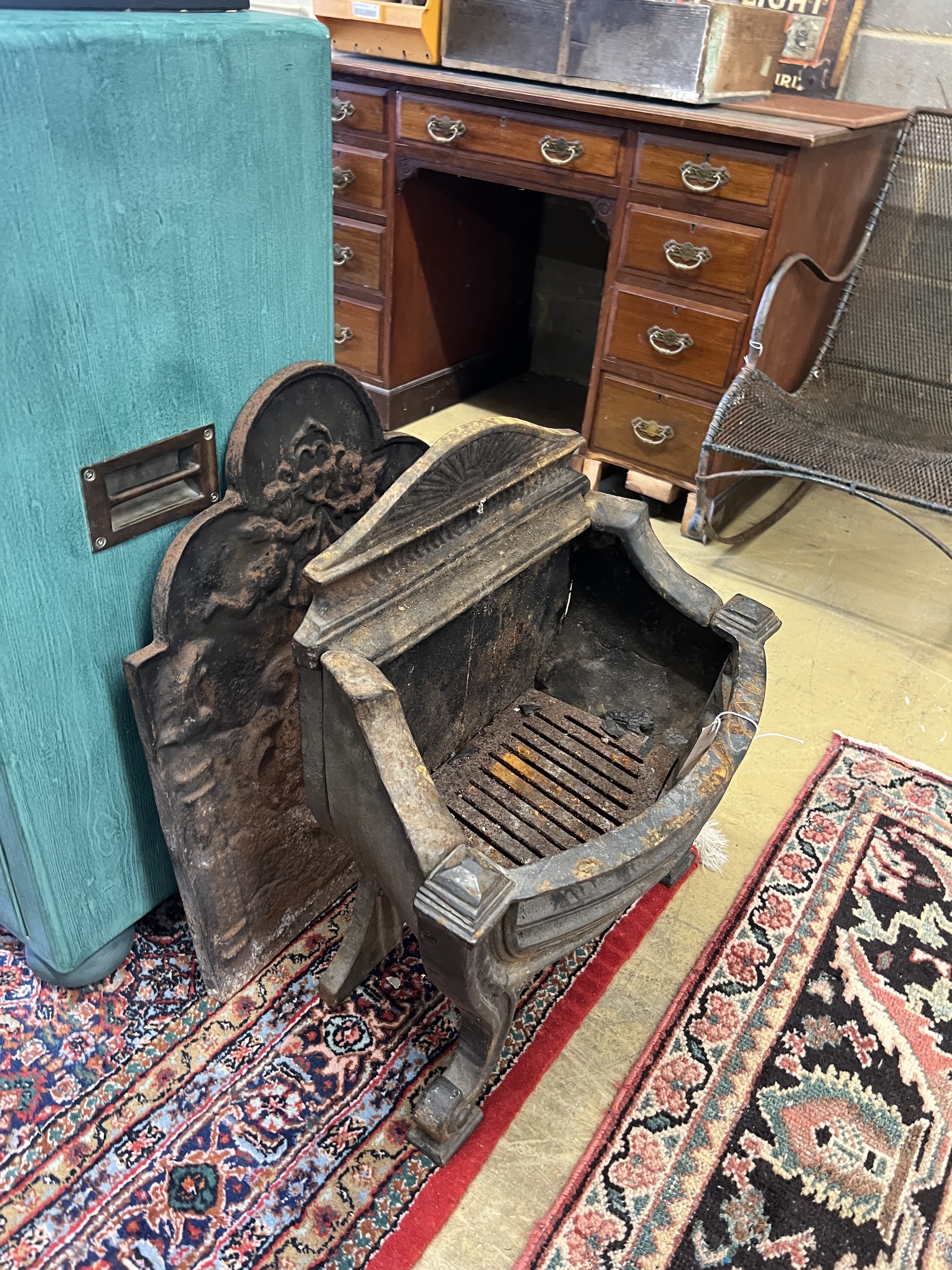 A 19th century cast iron bow front fire grate, width 56cm, depth 28cm, height 61cm together with a cast iron fire back